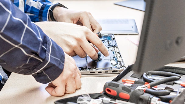 Ein Auszubildender im Bereich IT arbeitet an einem Laptop