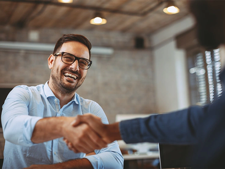 Two people shaking hands in an office