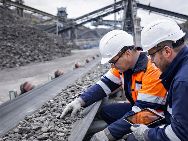 Two people having a visual inspection on a conveyor belt
