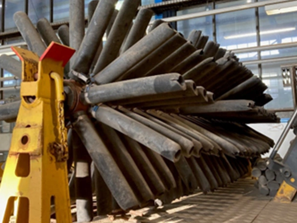 Rubber protection on sweepers of a ballast distributing machine