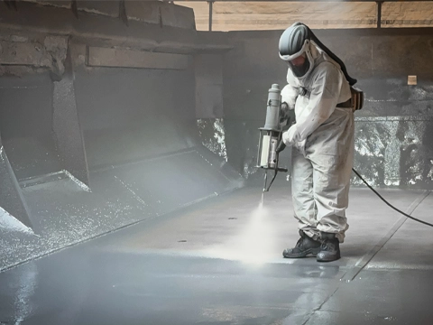 An employee applies the Lutze spray coating as wear protection