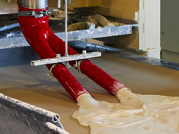 Polyurethane hose pouring plaster on a setting belt